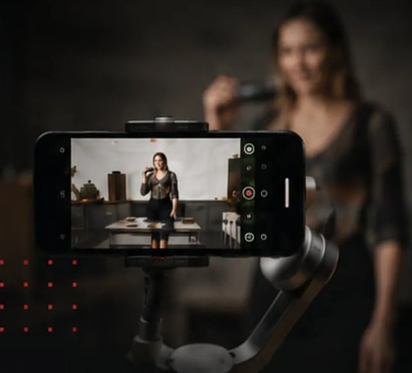 Smartphone sur stabilisateur filmant une créatrice