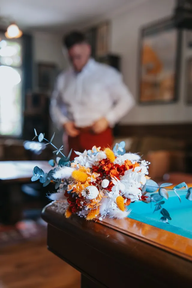 Bouquet posé sur un billard, le marié en arrière-plan